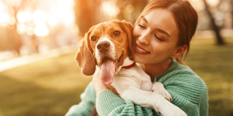 Tutora abrazando un beagle. Aprendé a cuidar a tu mascota en casos de epilepsia en perros.