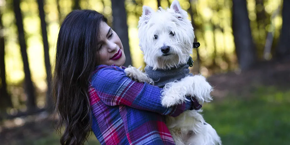 West Highland terrier junto a su tutora. Este perro es una gran compañía para adultos mayores.